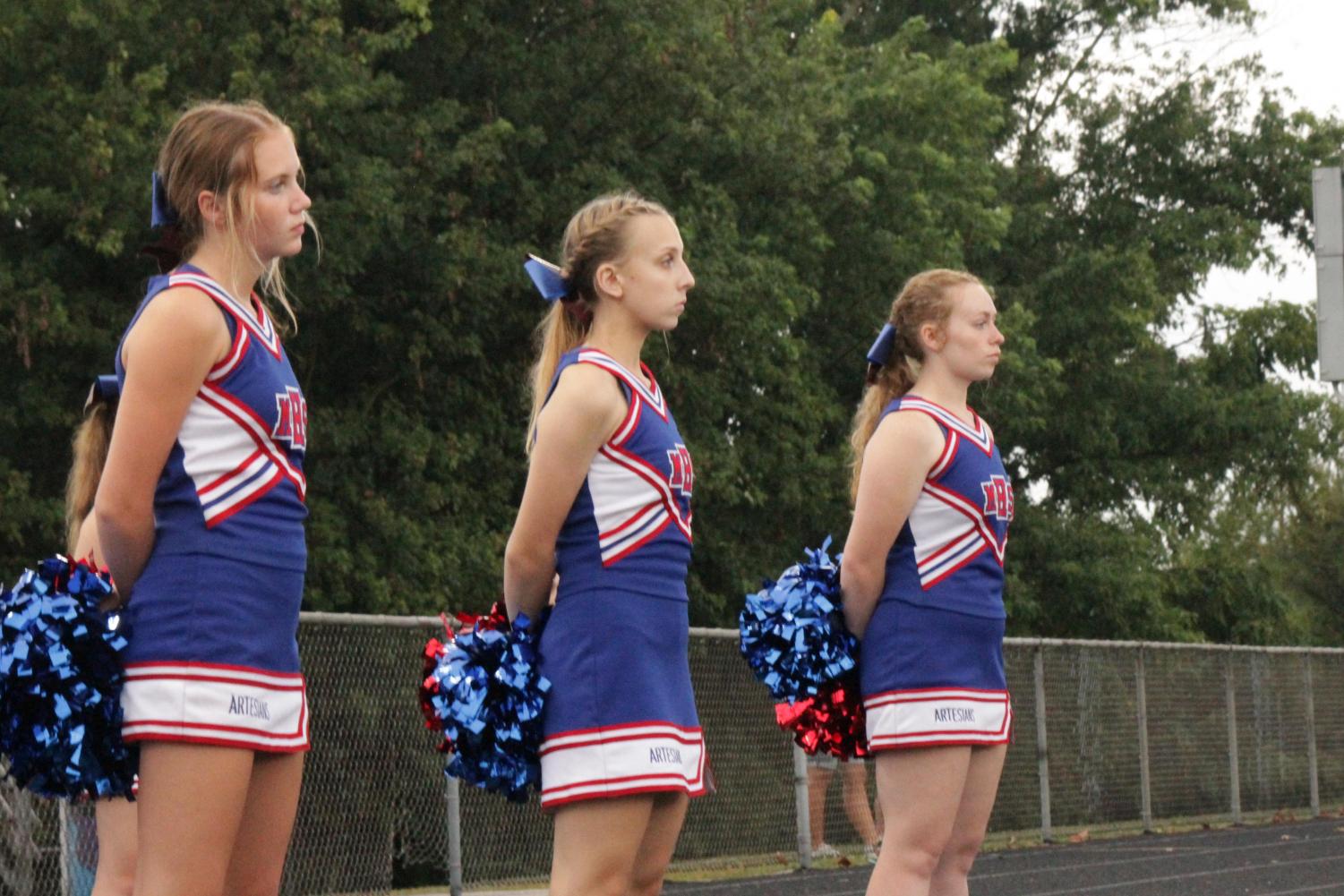 Paydin Baker, Maggie Watkins, and Piper Henson line up to watch the football game.